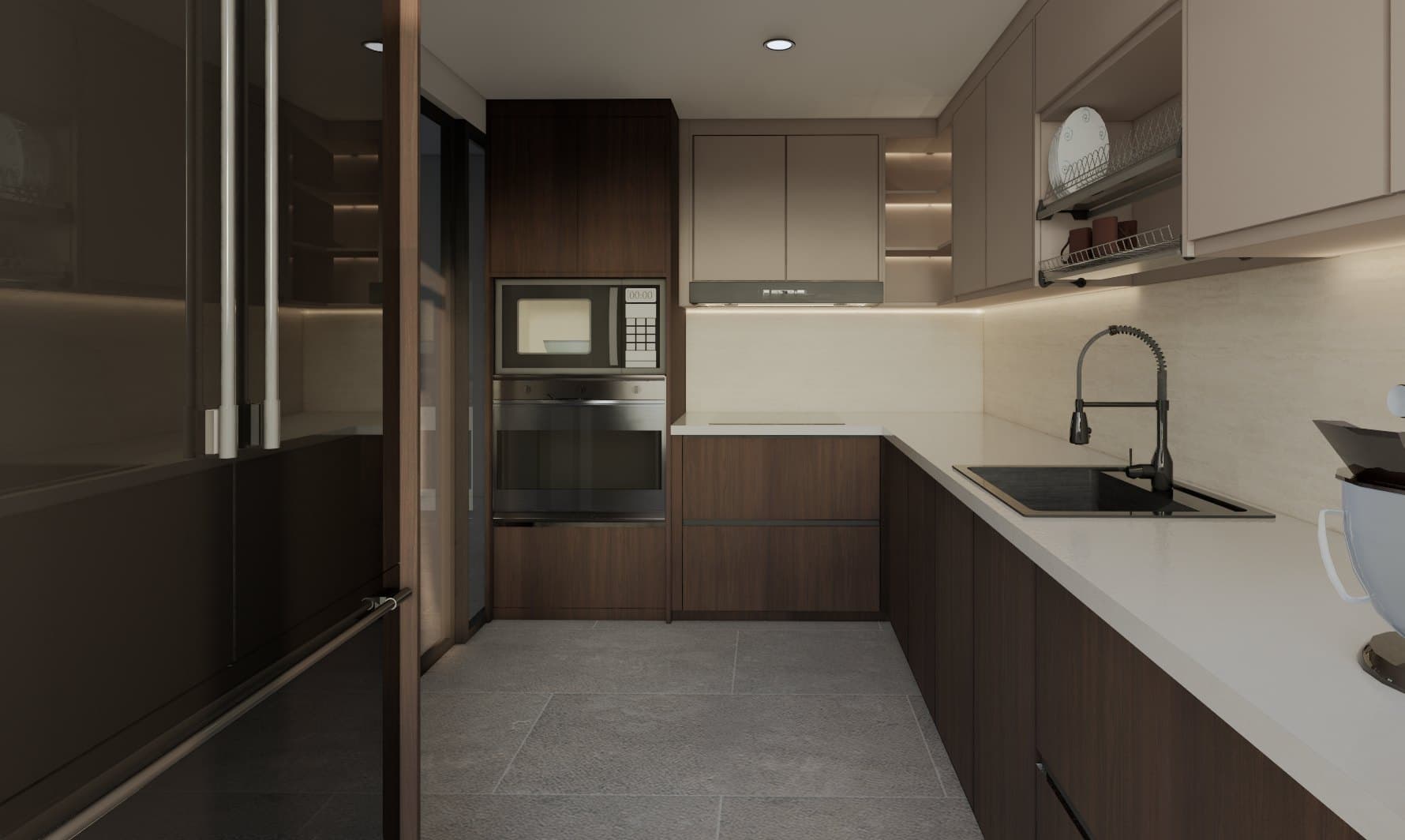 A galley kitchen with quartz counters, concealed tall storage and warm overhead lighting.