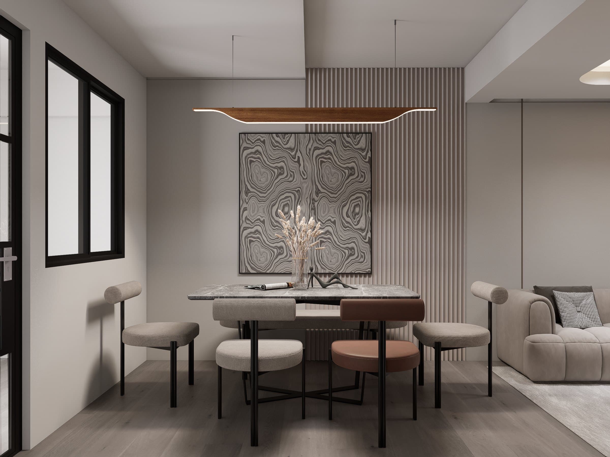 A dining setting under a sculptural pendant, anchored by an oak table and tonal seating.